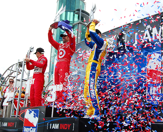 Podium finishing drivers Ryan Briscoe (2nd, on left) Dario Franchitti (1st, in centre) and Will Power (3rd on right) are blasted with confetti in winner's circle after the race. Photos/Matthew Filipowich