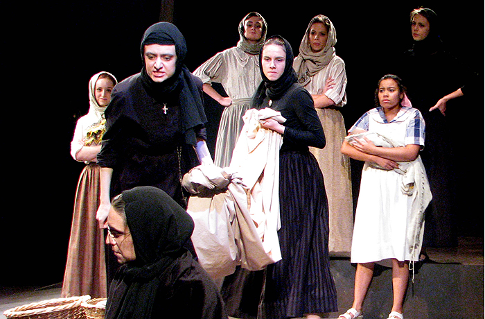 The matriarch Sofia is accused of endangering the village (seated Rachelle Magil with Sophia Fabiilli and ensemble).